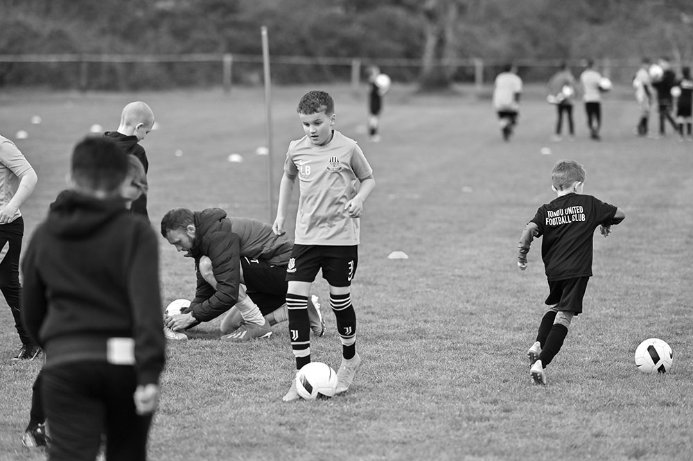 Image of the boys team playing football on a pitch