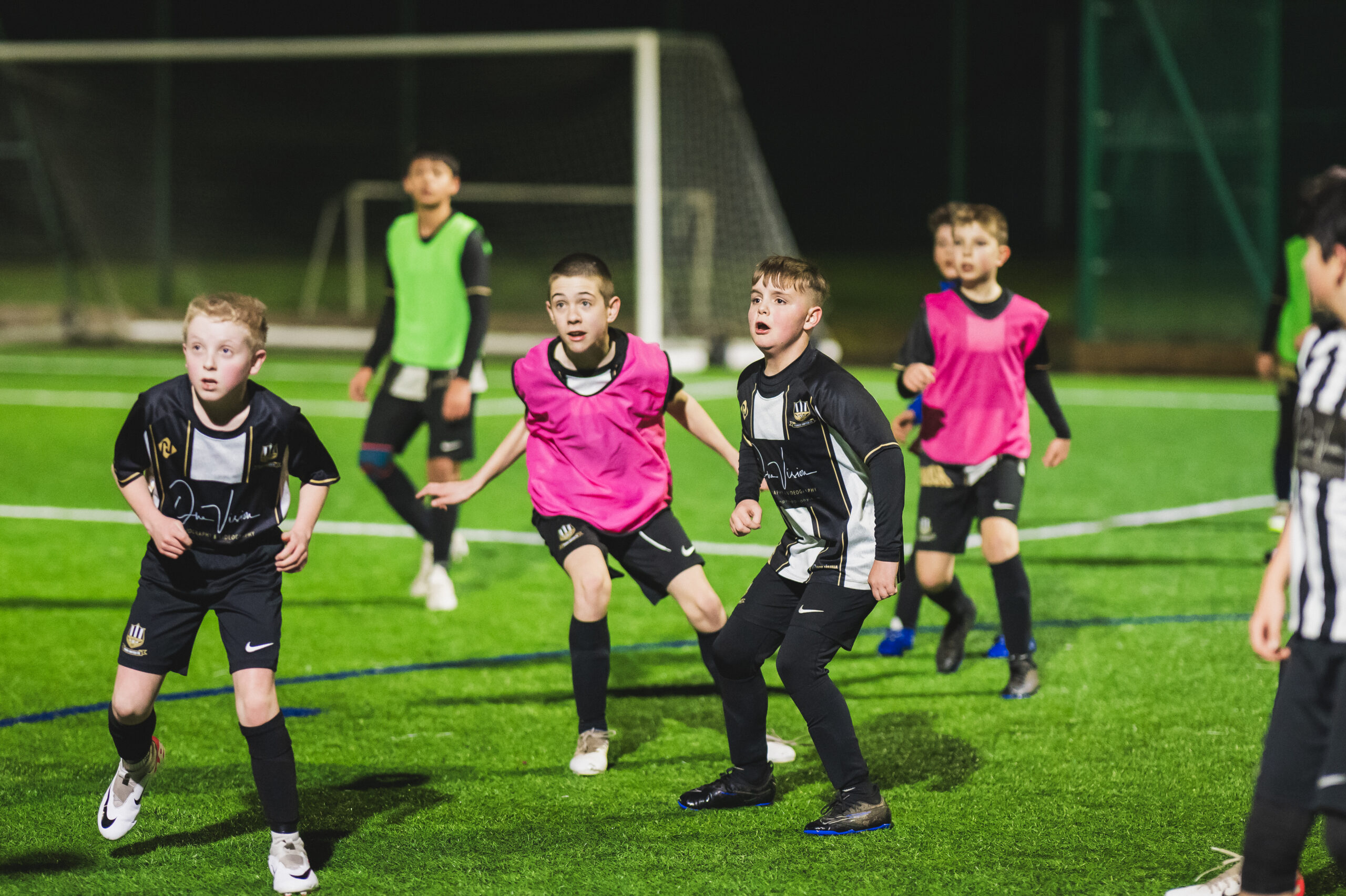 Some of the boys team playing football on a pitch