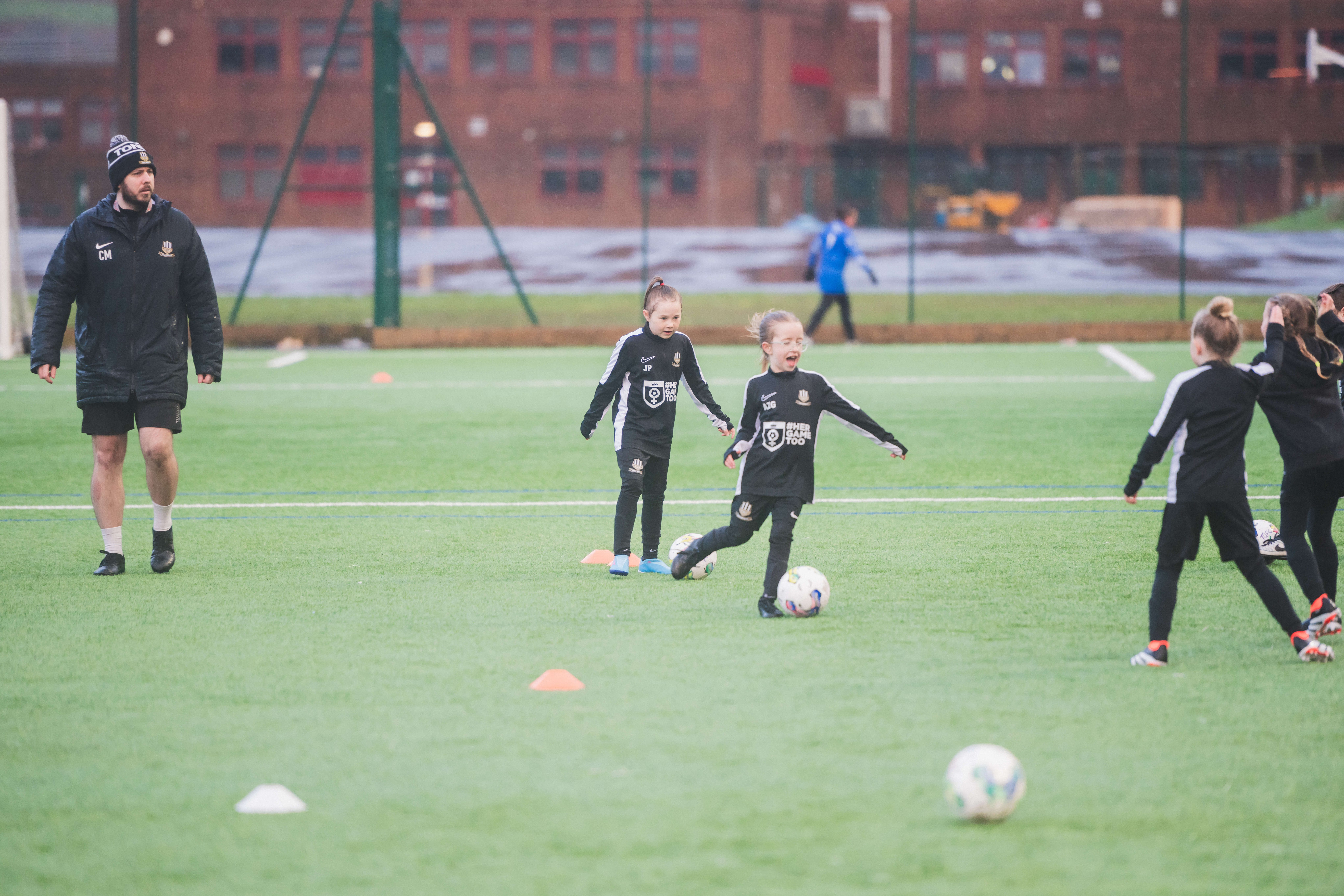 Two young girl players on a pitch playing football