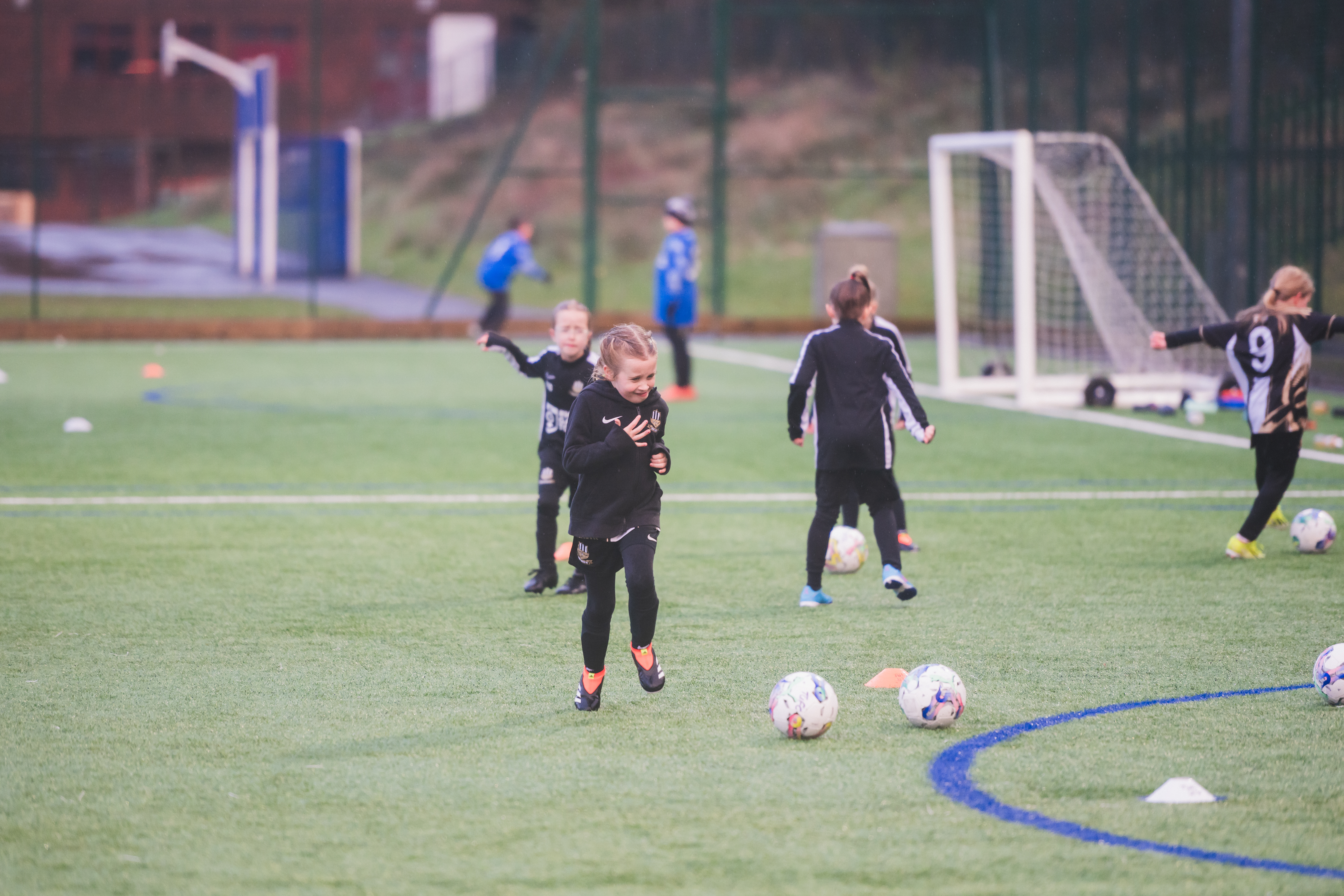 Girl players on a pitch playing football