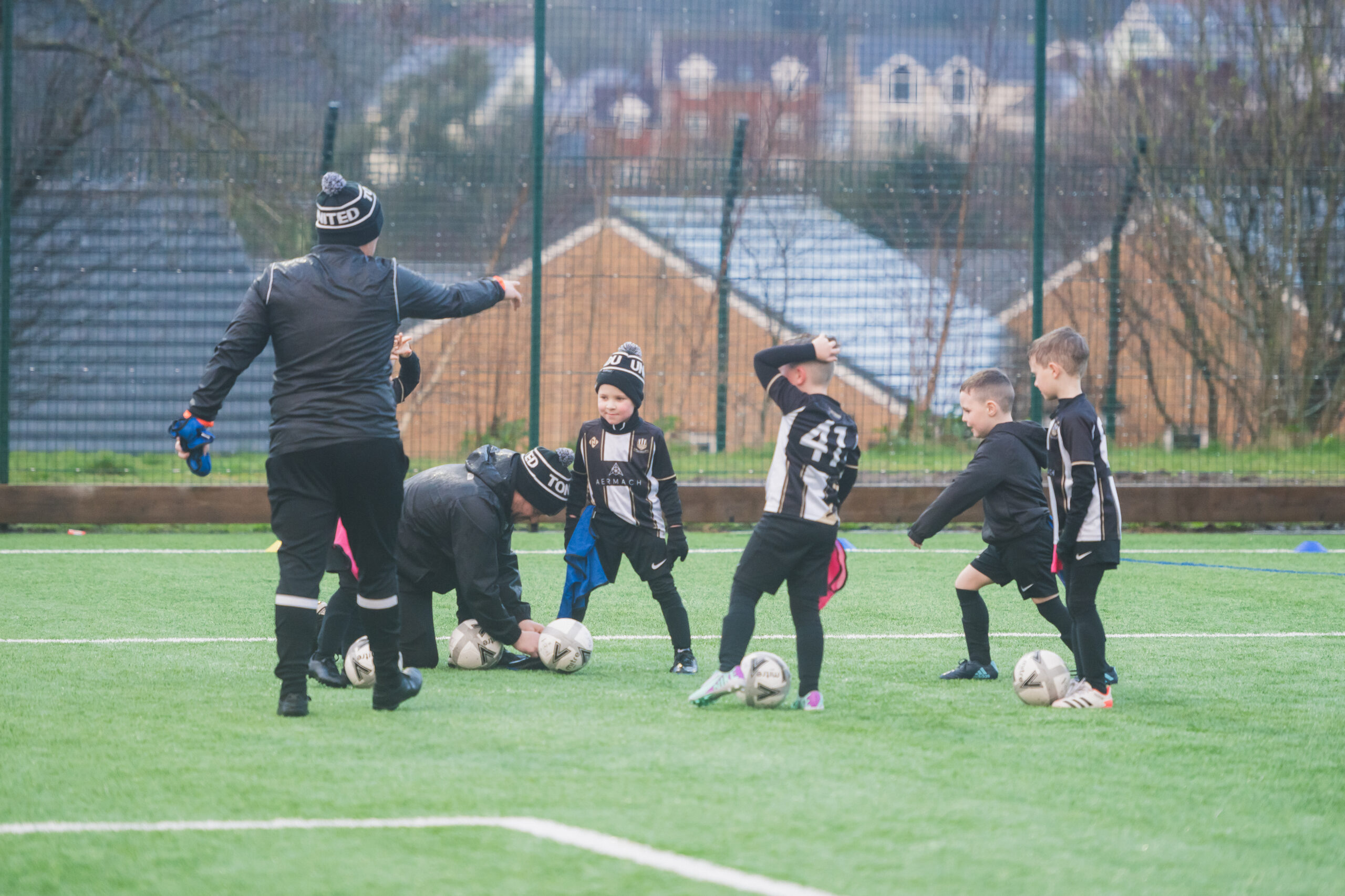 Coach with the boys team playing on a pitch